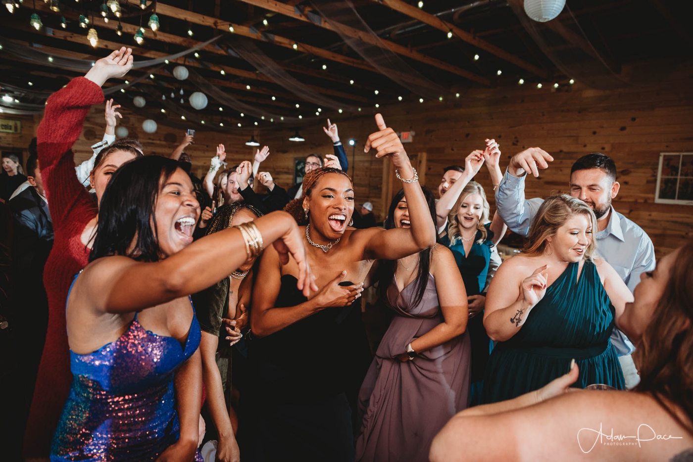 Wedding guests singing with their hands up on a packed barn dance floor in north Georgia