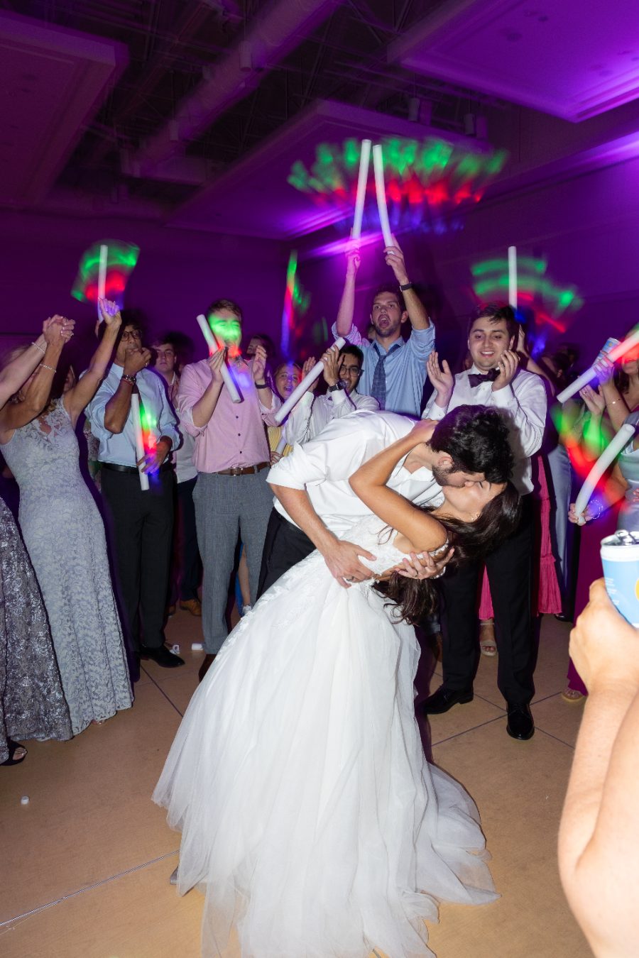 A dip kiss on the dance floor under deep purple uplighting at a Georgia wedding reception